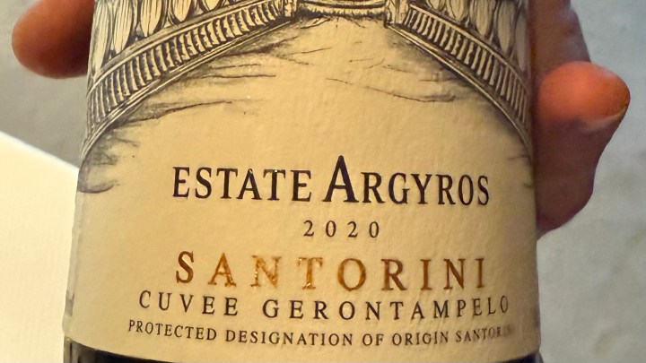 Close-up of a wine bottle label reading 'Estate Argyros 2020 Santorini Cuvee Gerontampelo' with intricate design and text.