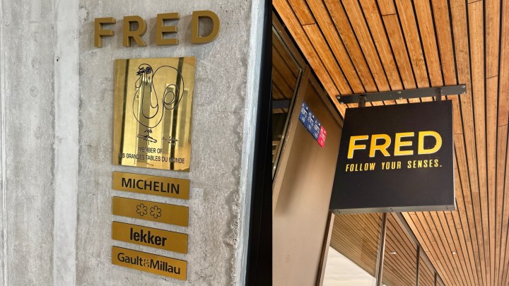 Entrance sign of restaurant Fred in Rotterdam featuring Michelin stars and a modern design.