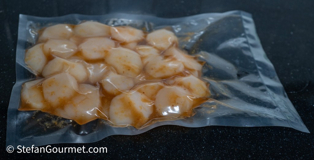 Vacuum-sealed scallops marinating in a flavorful dressing.