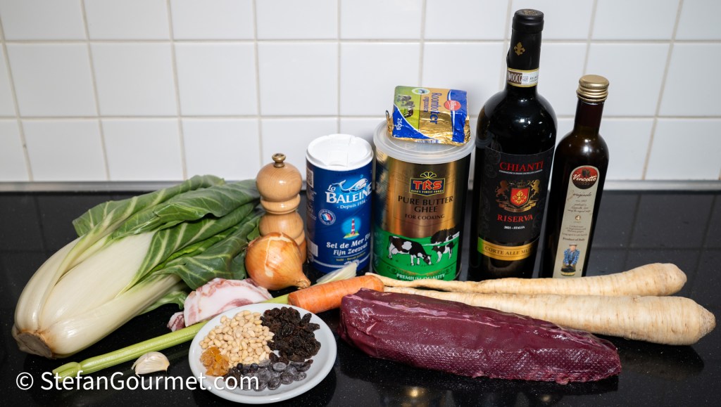An assortment of ingredients for a hare dish, including chard, parsley root, diced carrot, pine nuts, raisins, garlic, onion, hare fillet, Chianti wine, vinegar, and ghee, arranged on a black countertop.