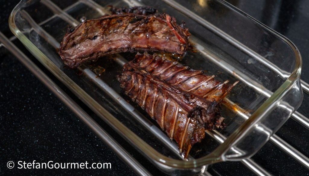 Roasted hare bones placed in a glass dish, with some caramelization evident on the surface.