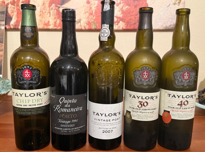 Five bottles of Taylor's port wine, including Chip Dry, Quinta da Romaneira 1994, Vintage Port 2007, 30 Year Old Tawny Port, and 40 Year Old Tawny Port, displayed on a wooden surface.
