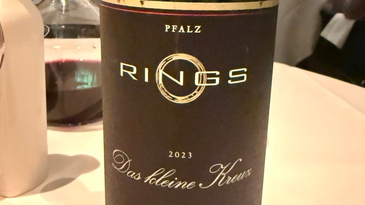A close-up of a wine bottle labeled 'RINGS' from the Pfalz region, vintage 2023, with the subtitle 'Das kleine Kreuz.'