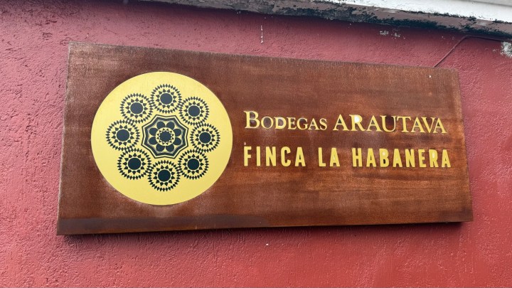 Sign for Bodegas Arautava, Finca La Habanera, featuring a decorative circular logo and the name in gold lettering on a wooden background.
